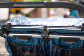 Am oberen Rand wird das Regenverdeck an drei Punkten eingehängt